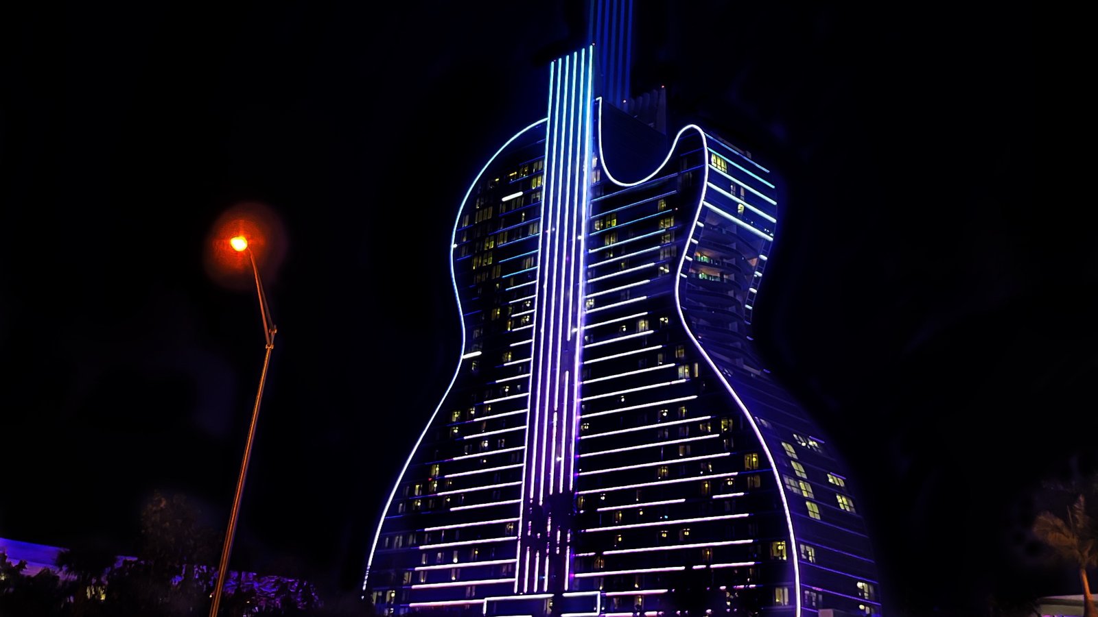 The Guitar Hotel at Seminole Hard Rock, Hollywood, lit up at night with its beam of light rising from the neck